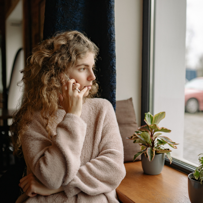 woman pondering and looking outside the window