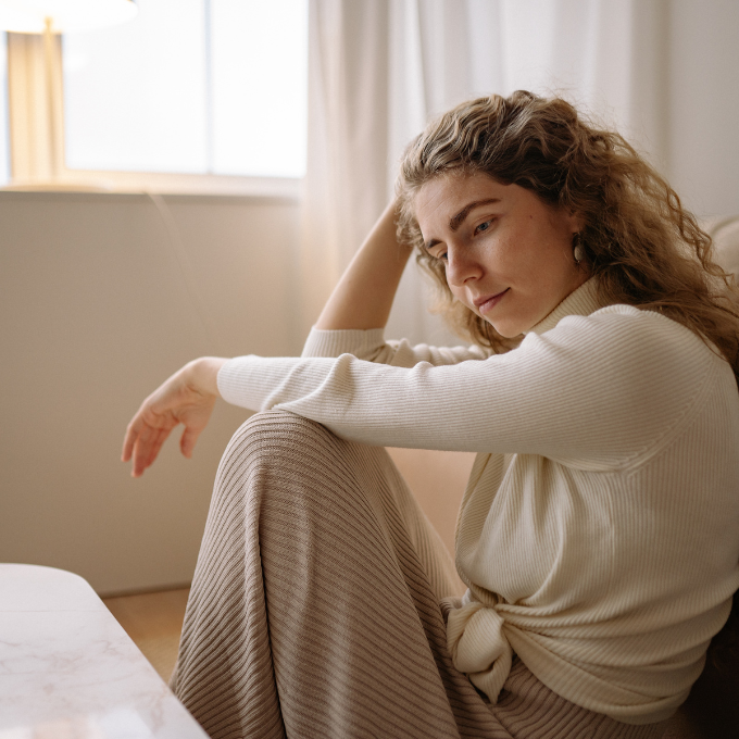 woman thinking and sitting on floor
